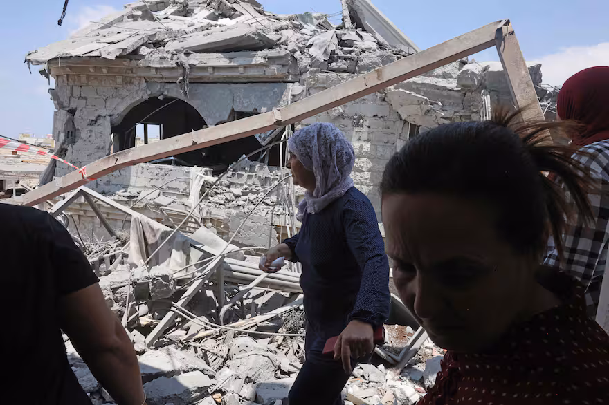 Vecinos de Tamra junto a una de las casas destruidas por los misiles